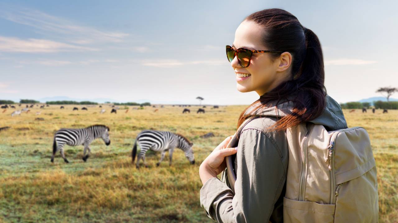 Exotická dovolená - Turistka s batohem a zebry
