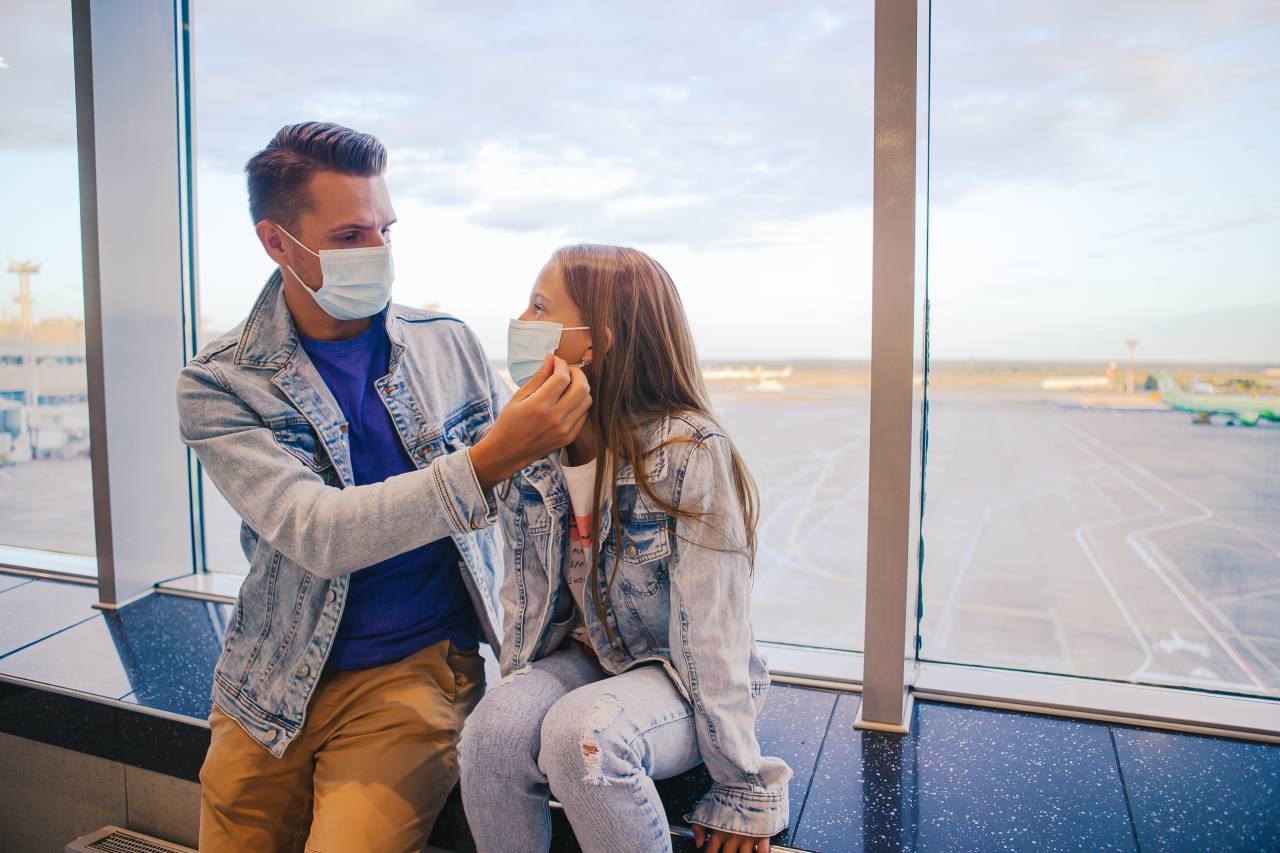 Koronavirus a cestovní pojištění - Otec s dcerou na letišti v rouškách